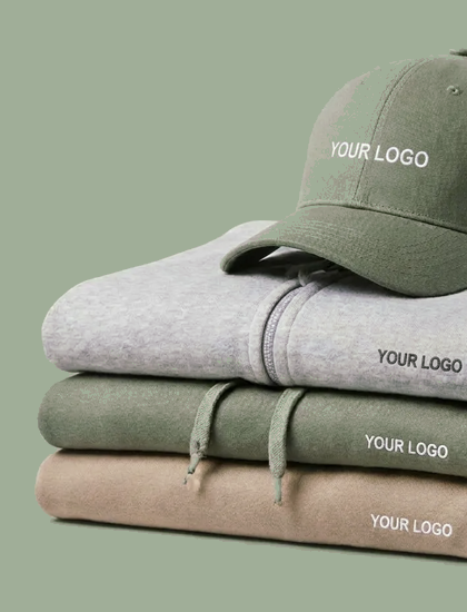 Imagen Sudaderas con capucha apiladas en gris, verde y beige, con una gorra verde y espacio para el logo